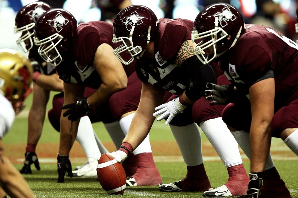 Dynamic shot of American football players in formation on the field, ready to start the game.