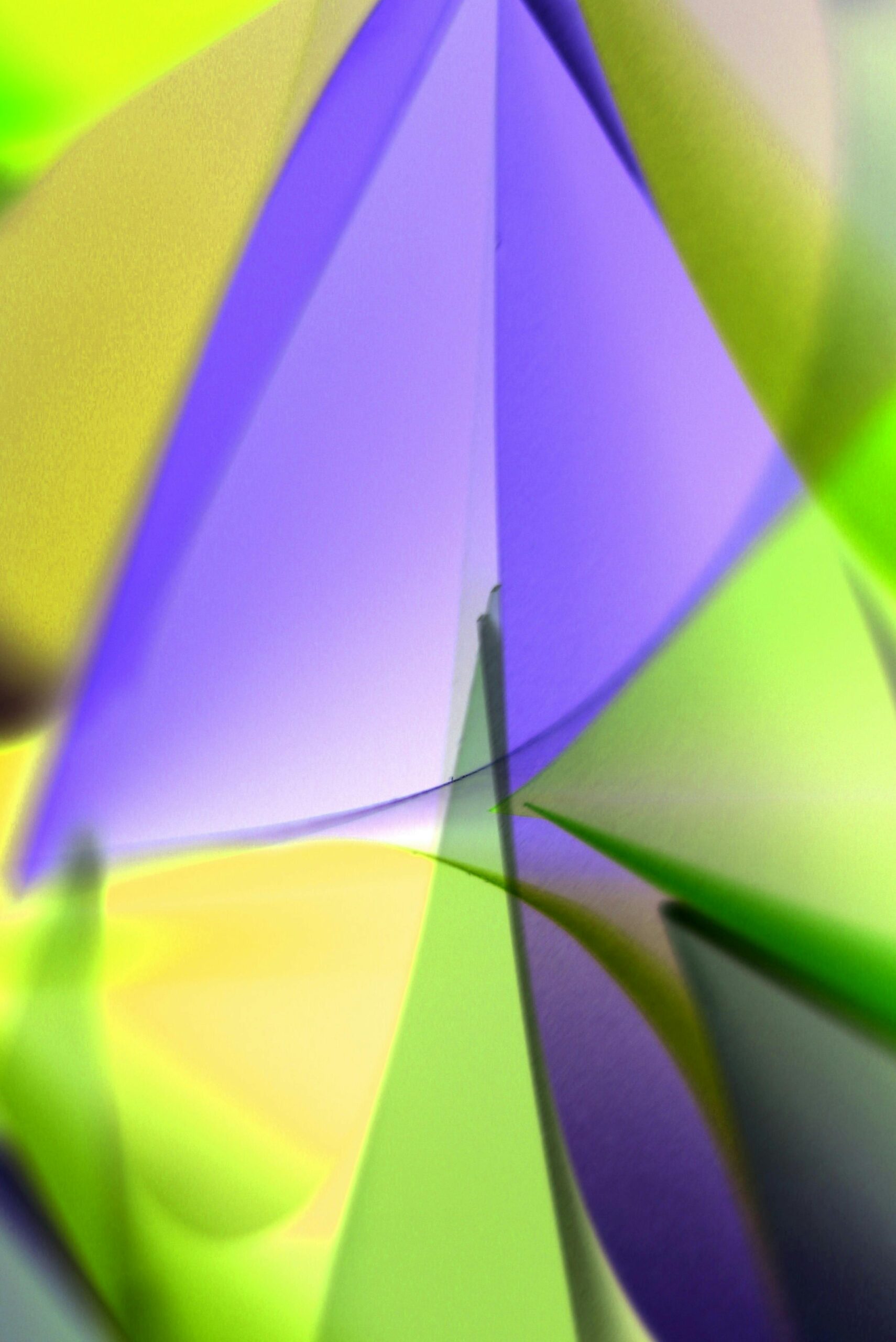 Colorful abstract art featuring dynamic green, purple, and yellow shapes.