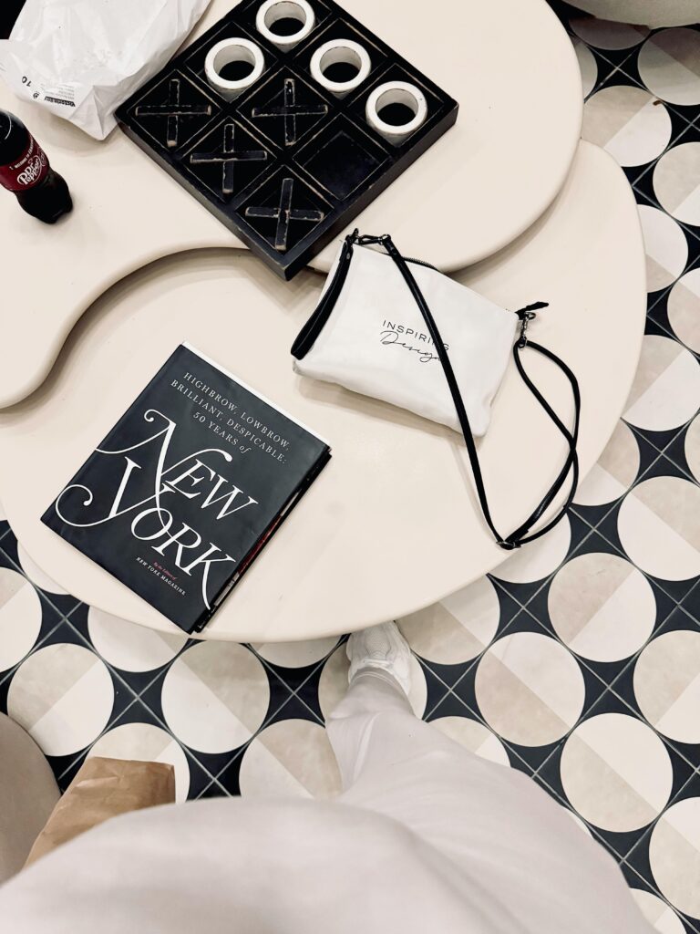 Stylish overhead shot featuring New York photography book and accessories on a patterned floor.